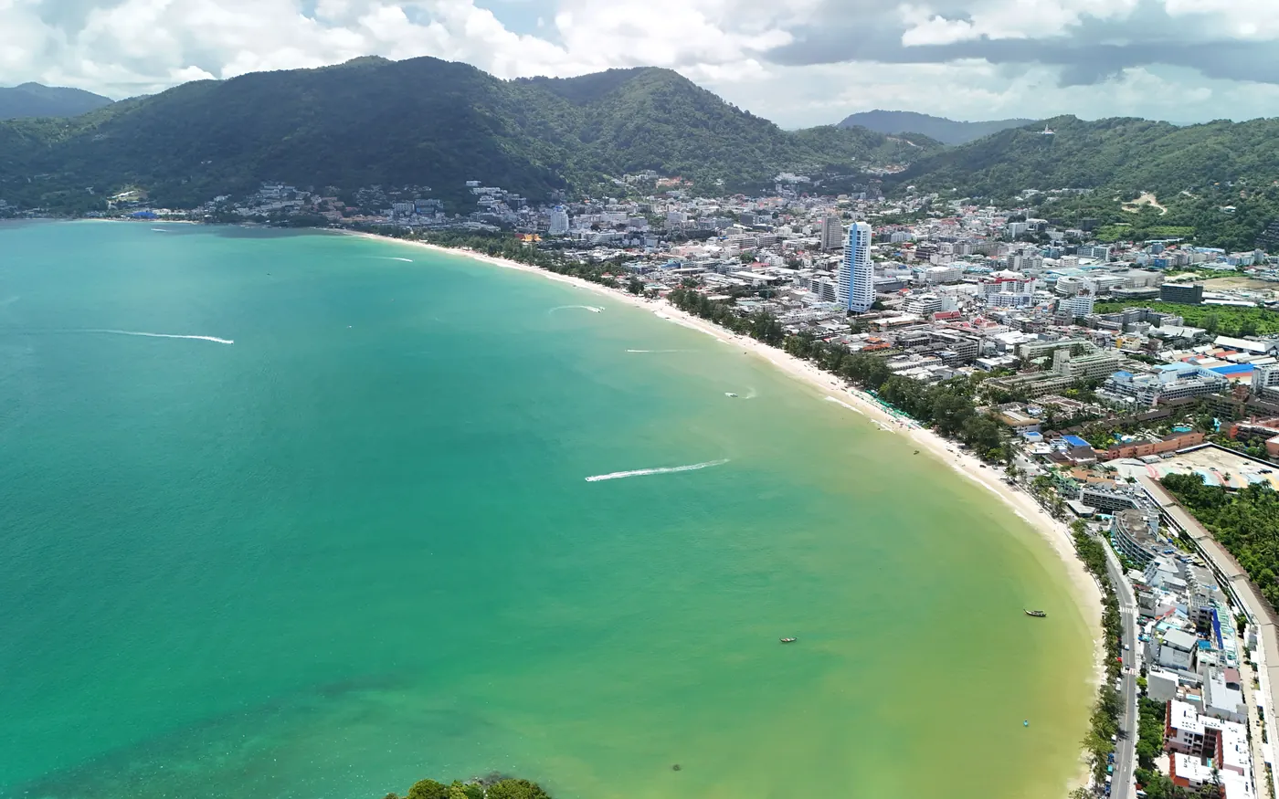 Aerial view of Patong Bay, Phuket, with the beach and town below green hills