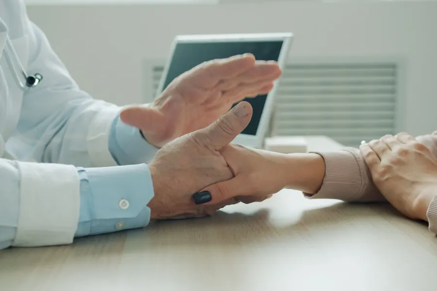 Doctor and patient talking across a desk during a private consultation