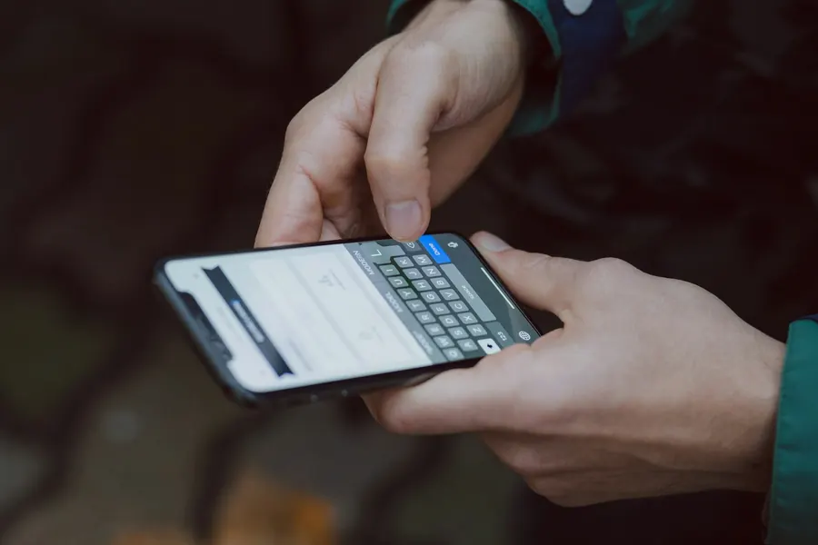 Hands typing a private message on a smartphone